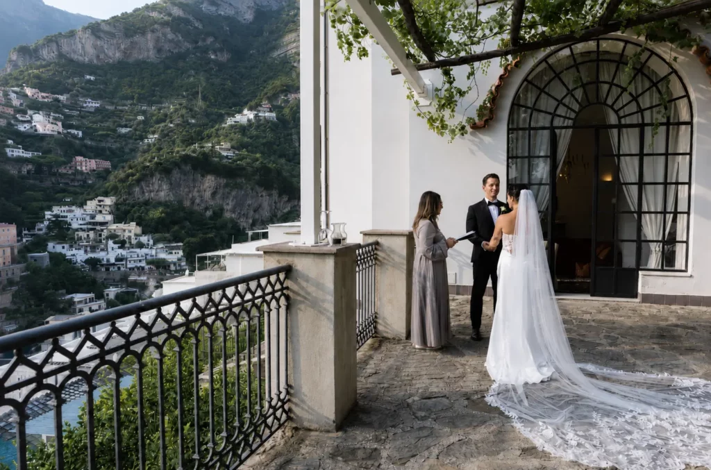 Bride and groom having a terrace wedding ceremony in Ravello, Italy, overlooking the Amalfi Coast cliffs