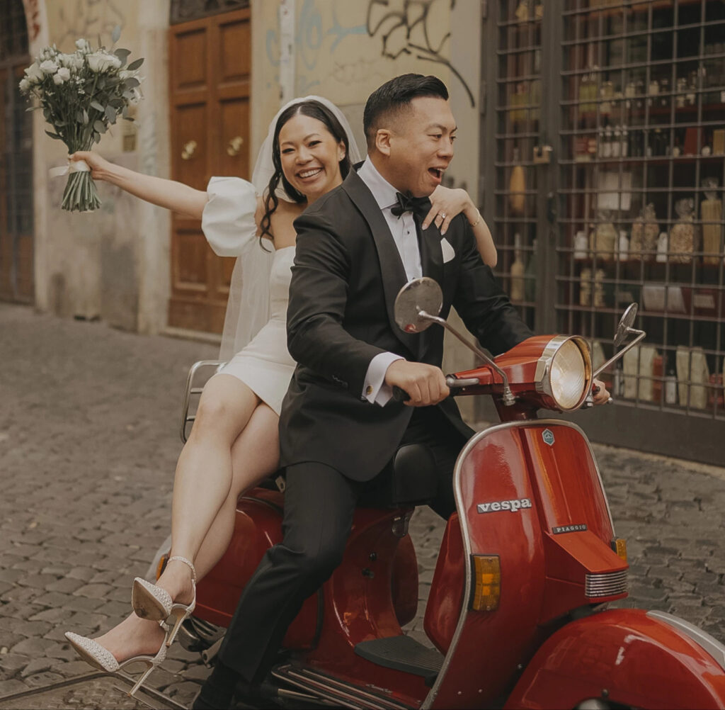 Newlyweds celebrating on a red Vespa during their Italy Elopement in Rome.