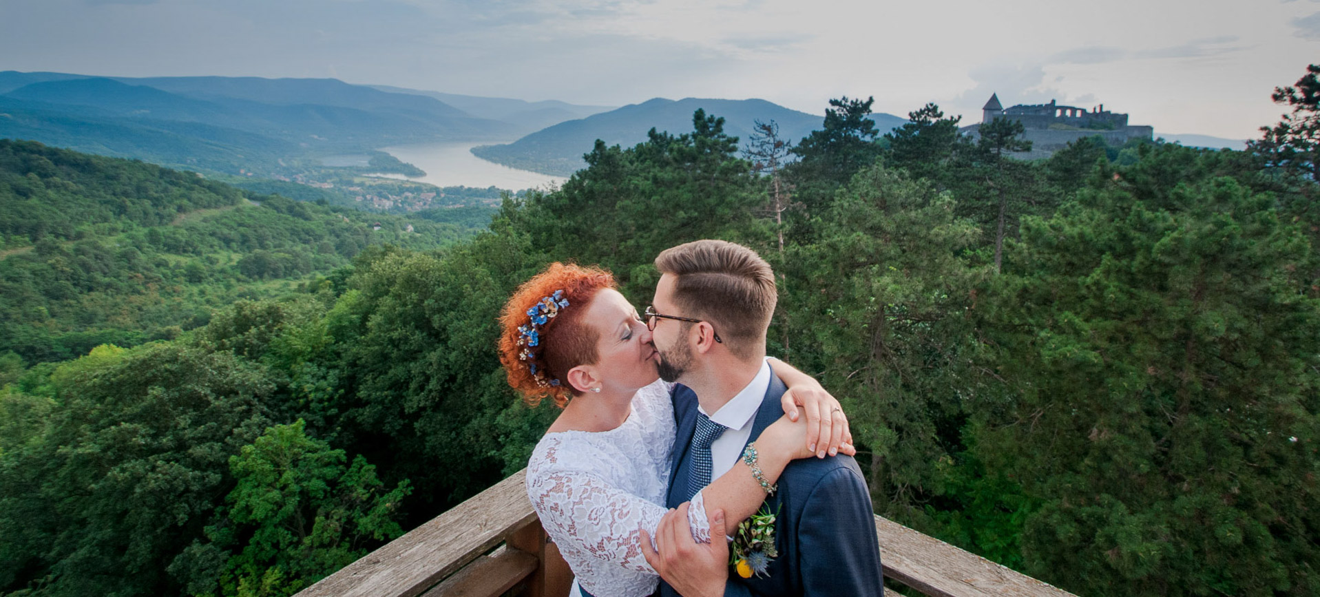 Riverside adventure wedding in HUngary, at the Danube Bend - couple kissing on a view point, with the hills and Danube river behind them