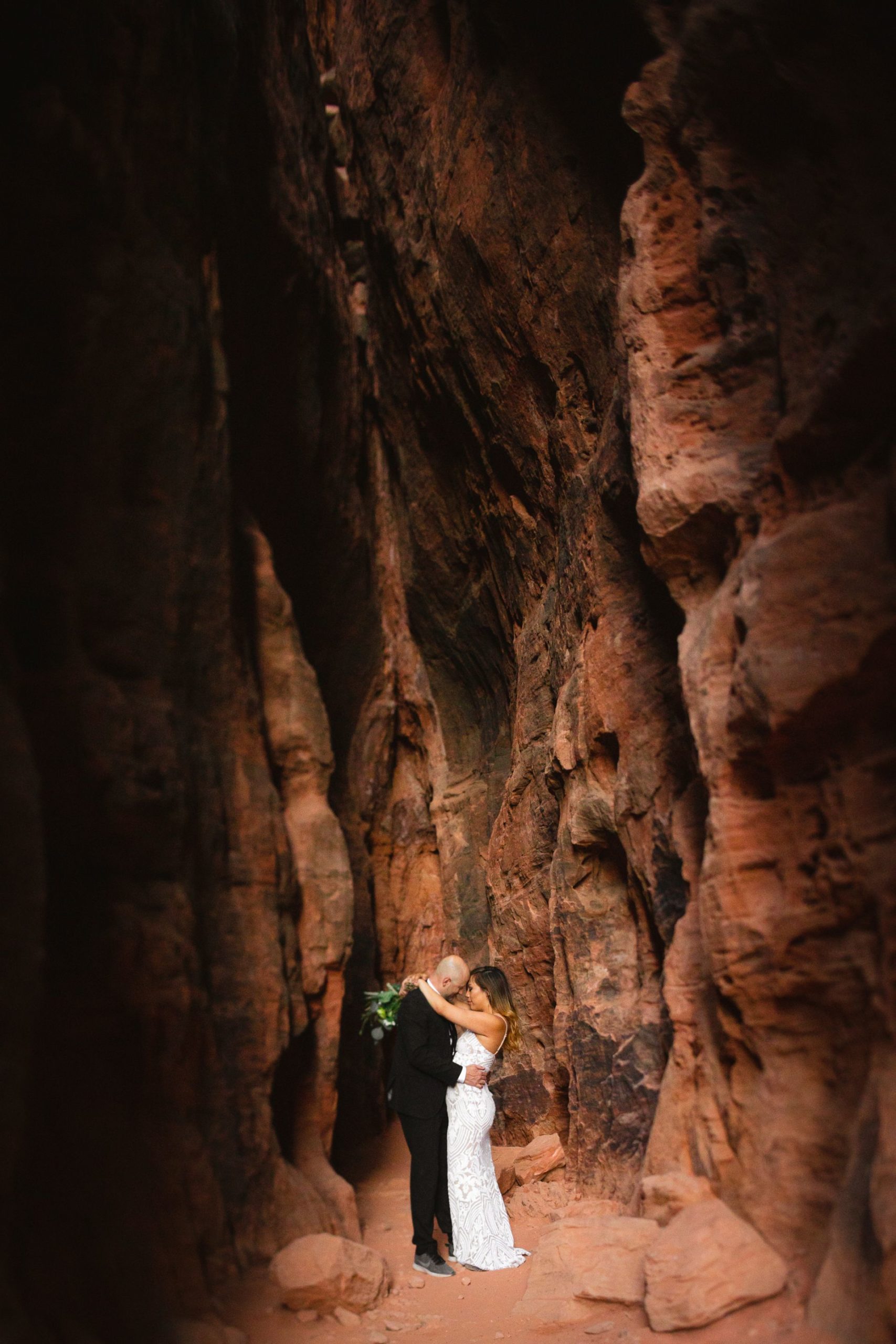 hike out wedding in the utah desert - couple hugging in spectacular canyon