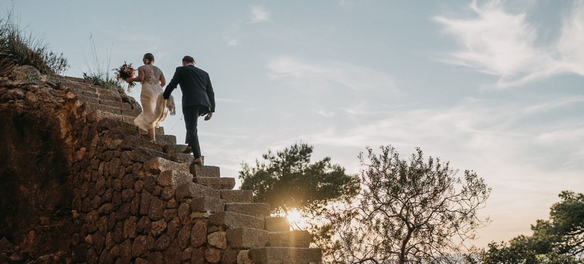 mallorca elopement photographer - adventure wedding in mallorca - groom walking up natural stairs to wedding ceremony