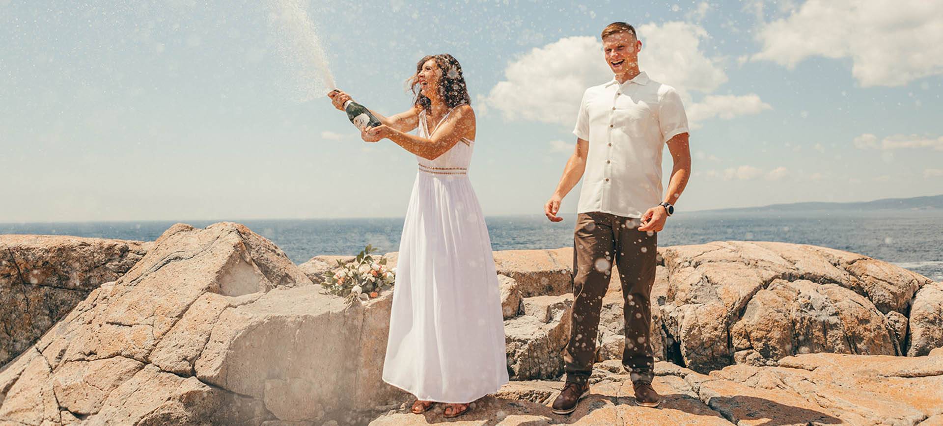 acadia national park wedding - bride & groom celebrating with champagne at the beach